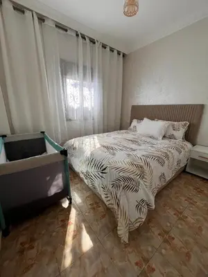 a bedroom with a bed with a comforter on it at cozy and spacious apartment in Marrakech