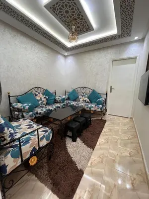 a living room with two beds and a table at cozy and spacious apartment in Marrakech