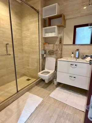 a bathroom with a shower and a toilet and a sink at Palmeraie Garden Luxury Appartement Family Only in Marrakech