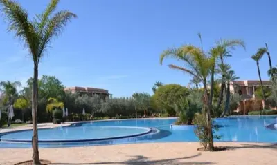 a large swimming pool with palm trees in a resort at Palmeraie Garden Luxury Appartement Family Only in Marrakech