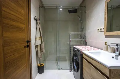a bathroom with a shower and a washing machine at Luxurious and Cozy Apartment with Parking and View in Marrakech