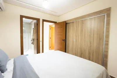 a bedroom with a white bed and a wooden closet at Luxurious and Cozy Apartment with Parking and View in Marrakech