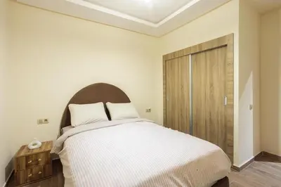 a bedroom with a large bed and a wooden door at Luxurious and Cozy Apartment with Parking and View in Marrakech