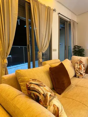 a yellow couch in a living room with curtains at Appartement plaza in Marrakech