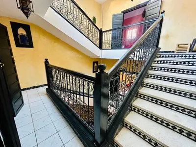 a spiral staircase with black railings in a house at B&B Lina Stay Marrakech in Marrakech