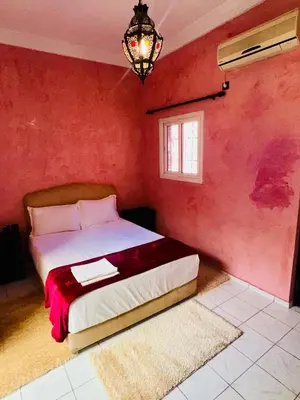 a bedroom with a bed with a red wall at B&B Lina Stay Marrakech in Marrakech