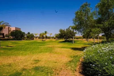a field of grass with trees and bushes at Prestigia Appartment Golf & 3 Pools in Marrakech
