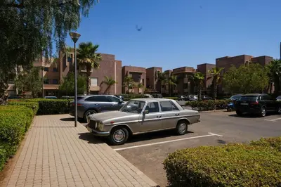 an old car parked in a parking lot at Prestigia Appartment Golf & 3 Pools in Marrakech
