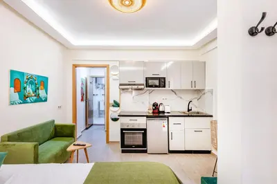 a small kitchen and living room with a green couch at Studio chic et cosy au cœur de Guéliz in Marrakech