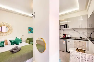 a bedroom with a bed with a mirror and a kitchen at Studio chic et cosy au cœur de Guéliz in Marrakech