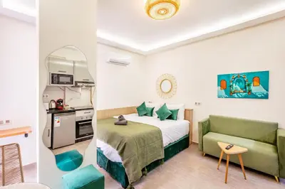 a hotel room with a bed and a green couch at Studio chic et cosy au cœur de Guéliz in Marrakech