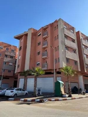a large building with palm trees in front of it at Marrakech mahamid location vacances 3 chember in Marrakech