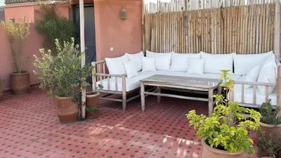 a white couch on a patio with potted plants at Riad Lana Marrakech - Dar el Bacha Luxury Suites in Marrakech