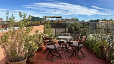 a patio with a table and chairs and plants at Riad Lana Marrakech - Dar el Bacha Luxury Suites in Marrakech