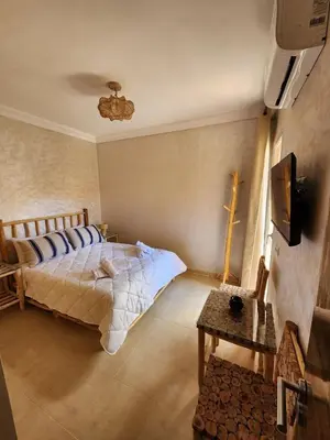 a bedroom with a bed and a tv on a wall at Cozy flat near airport in Marrakech