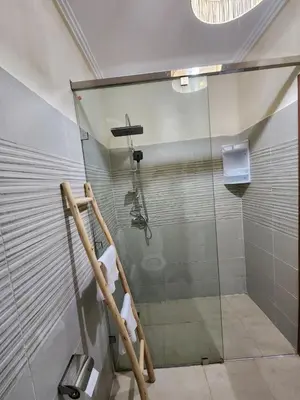 a shower with a glass door in a bathroom at Cozy flat near airport in Marrakech