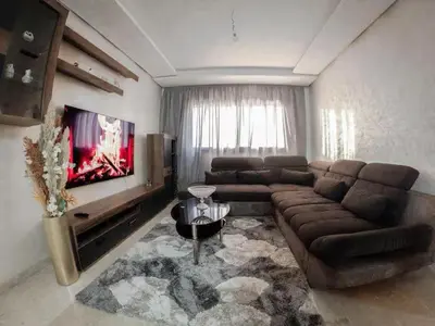 a living room with a couch and a flat screen tv at Jnane El Ali 3 in Marrakech