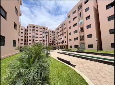 a courtyard with two large buildings and palm trees at Jnane El Ali 3 in Marrakech