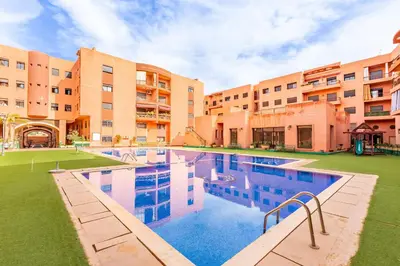 an image of a swimming pool in front of a building at Oasis Familiale Marrakech Piscine & Résidence Sécurisée in Marrakech