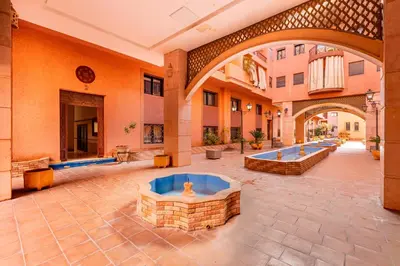 an empty courtyard with two fountains in a building at Oasis Familiale Marrakech Piscine & Résidence Sécurisée in Marrakech