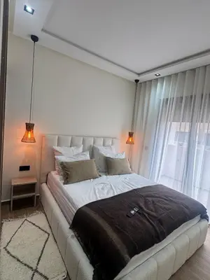 a bedroom with a large bed with two lamps at Cozy apartment Kenza Menara Garden 2 - 2 rooms in Marrakech
