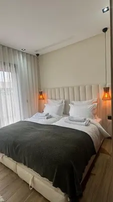 a large bed in a bedroom with two lamps at Cozy apartment Kenza Menara Garden 2 - 2 rooms in Marrakech
