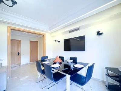 a dining room with a black table and blue chairs at Confort Signature - Piscine, balcon & parking in Marrakech