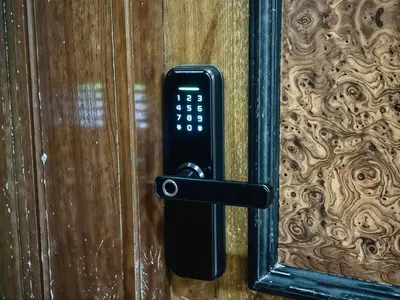 a remote control sticking out of a wooden door at Confort Signature - Piscine, balcon & parking in Marrakech