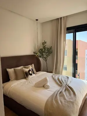 a bedroom with a large bed with a large window at Refined apartment with rooftop pool in Marrakech