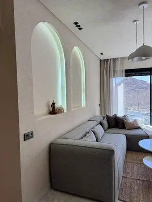 a living room with a gray couch and a window at Refined apartment with rooftop pool in Marrakech