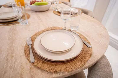 a wooden table with plates and wine glasses on it at Spacious duplex Private HEATED pool Jacuzzi in Marrakech