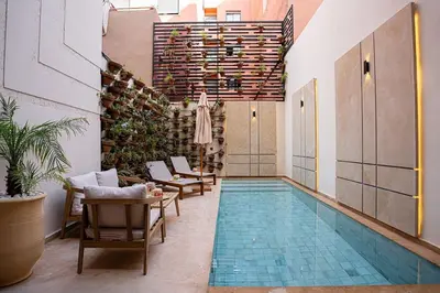 a pool in a room with chairs and a table at Spacious duplex Private HEATED pool Jacuzzi in Marrakech