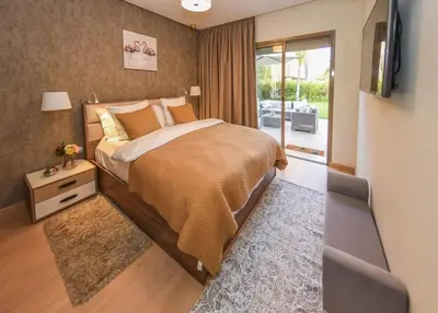 a bedroom with a bed and a tv and a balcony at Prestigia Jade in Marrakech