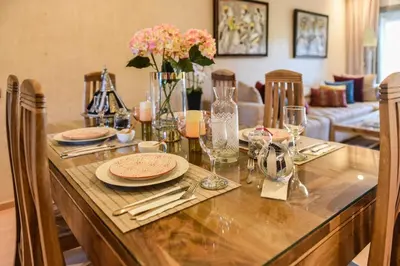 a dining table with plates and glasses and flowers on it at Prestigia Jade in Marrakech
