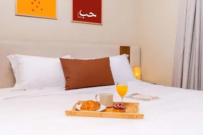 a tray of food and a glass of orange juice on a bed at Lalla Homes 369 in Marrakech