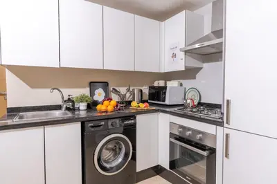 a kitchen with white cabinets and a dishwasher at Lalla Homes 369 in Marrakech