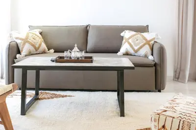 a living room with a couch and a coffee table at Appartement 2 chambres avec grand jardin Noria Golf in Marrakech