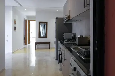a kitchen with a sink and a stove top oven at Appartement 2 chambres avec grand jardin Noria Golf in Marrakech