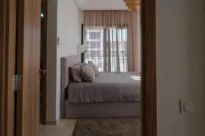 a bedroom with a bed and a window at Appartement 2 chambres avec grand jardin Noria Golf in Marrakech