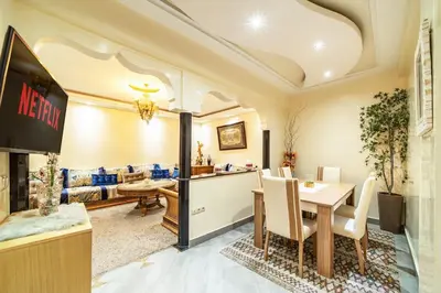a dining room and living room with a table and chairs at Spacious & Modern Guéliz Apart - 5 min to Airport in Marrakech