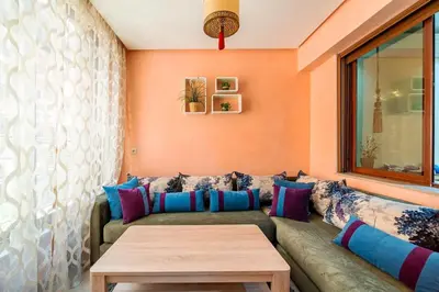 a living room with a couch and a table at Spacious & Modern Guéliz Apart - 5 min to Airport in Marrakech
