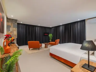 a bedroom with a bed and chairs in a room at Rixos Palm villas with a heated private pool & garden in Marrakech