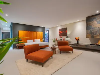 a bedroom with a bed and two chairs and a fireplace at Rixos Palm villas with a heated private pool & garden in Marrakech