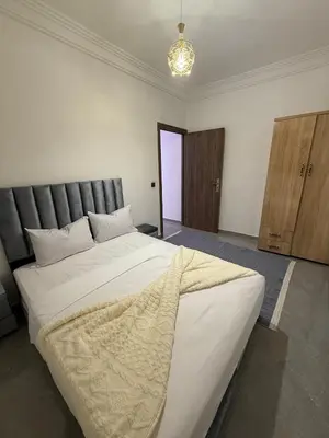 a bedroom with a large white bed with a blanket on it at Marrakech appartement in Marrakech