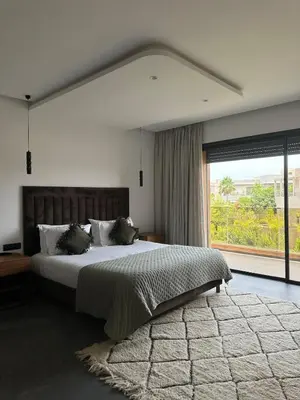 a bedroom with a large bed and a large window at Exceptional Villa Noria Golf in Marrakech