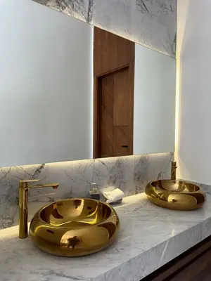 a bathroom with two gold sinks on a marble counter at Exceptional Villa Noria Golf in Marrakech