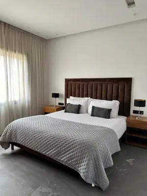 a bedroom with a large bed and two night stands at Exceptional Villa Noria Golf in Marrakech