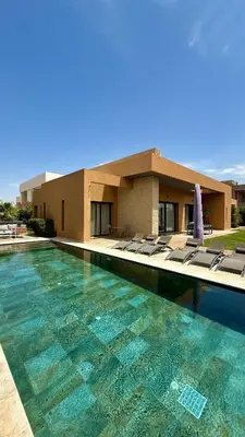 a swimming pool with lounge chairs in front of a building at Luxury villa Noria golf club in Marrakech