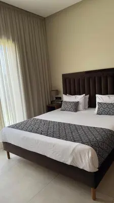 a bedroom with a large bed with a wooden headboard at Luxury villa Noria golf club in Marrakech