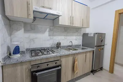 a kitchen with a sink and a stove and a refrigerator at Family apartment Jardins Chrifia in Marrakech